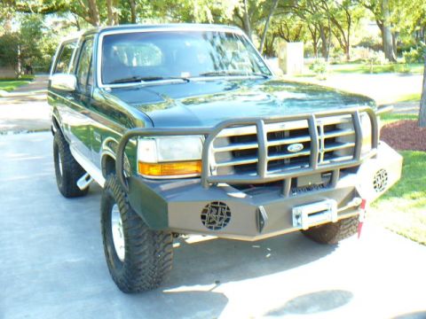 1992 Ford Bronco - Green 1992 Ford Bronco parked on a driveway with a custom front bumper and winch installed.