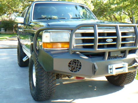 1992 Ford Bronco - A 1992 Ford Bronco is equipped with a heavy-duty brush guard and winch, parked on a paved surface.