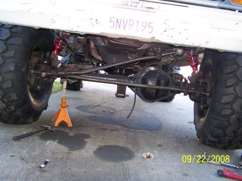 1982 Ford Bronco - Undercarriage view of a 1982 Ford Bronco, showing suspension components and large off-road tires.