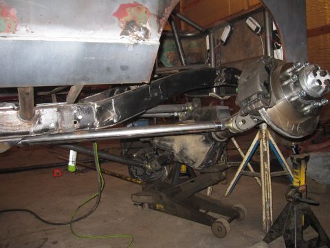 1992 Ford Bronco - Vehicle frame and suspension undergoing custom modification work in a workshop setting.