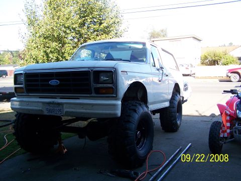 1982 Ford Bronco - This lifted 1982 Ford Bronco is shown from the front, with a red ATV visible on the right side.