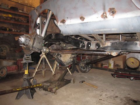 1992 Ford Bronco - Underbody of a vehicle undergoing modification, with suspension and chassis parts exposed.