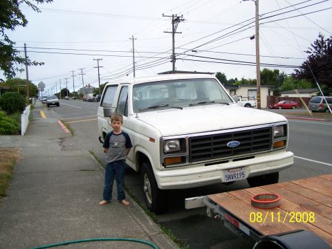 1982 Ford Bronco - A boy stands next to a white Ford Bronco on a street, with a trailer in the foreground.