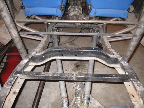 1992 Ford Bronco - The underside of a heavily modified vehicle reveals its custom frame and interior components.