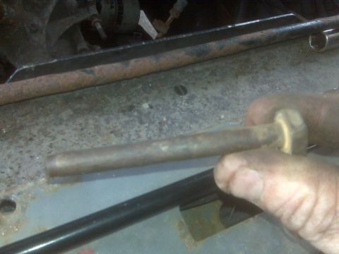 1995 Ford Bronco - Close-up of a hand holding a bolt near the rusty frame of a vehicle, with 'SUPERMOTORS' watermark visible.