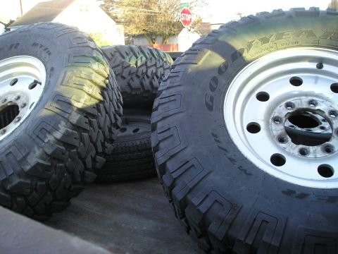 1997 Ford F-250 - Close-up view of several large tires and their rims, likely for an off-road vehicle.
