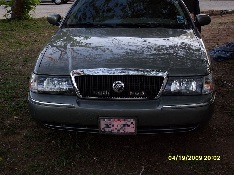 Front view of a gray Mercury Grand Marquis with a chrome grille and a license plate