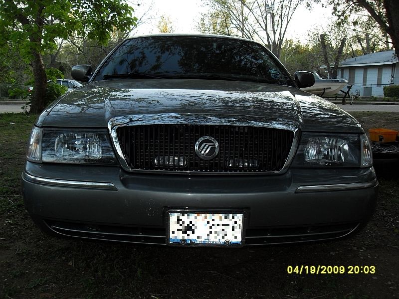 Front view of a 2004 Mercury Grand Marquis with a chrome grille and headlights. License plate is blurred
