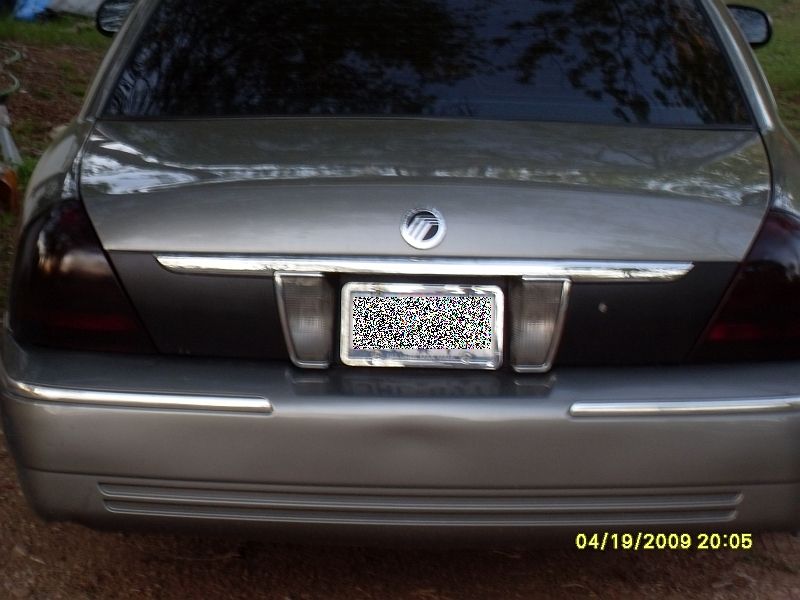 Rear of a silver 2004 Mercury Grand Marquis with tinted taillights and a chrome strip