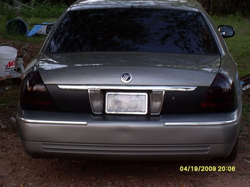 Rear view of a silver Mercury Grand Marquis with tinted taillights and a license plate