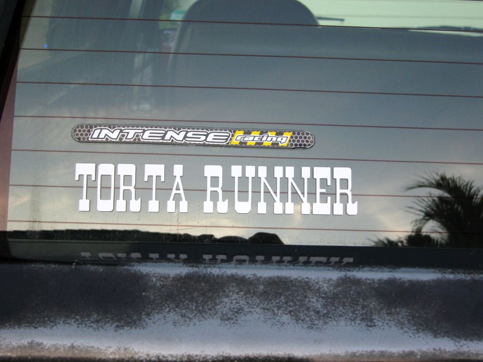 Rear window with 'INTENSE racing' and 'TORTA RUNNER' stickers. 'SUPERMOTORS.NET' logo at bottom