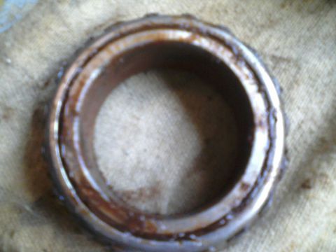 1986 Ford Bronco - A used wheel bearing shows signs of wear and rust, indicating it is a part rather than a vehicle.