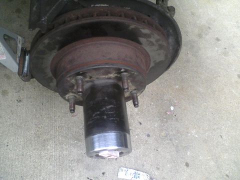 1986 Ford Bronco - Close-up of a vehicle's brake rotor and hub assembly, likely undergoing maintenance.