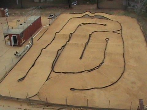 1986 Ford Bronco - An outdoor track designed for radio-controlled cars features dirt jumps and a black border.