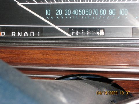 1985 Ford LTD - Close-up of a car's dashboard, a speedometer and odometer with visible mileage.