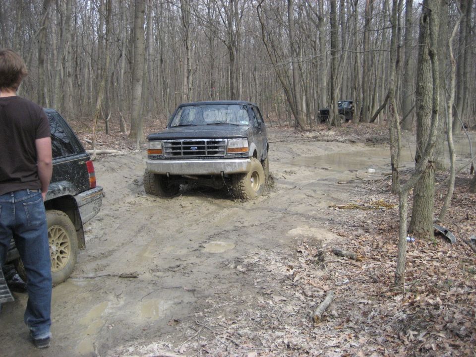 1991 Ford Bronco driving through mud pit