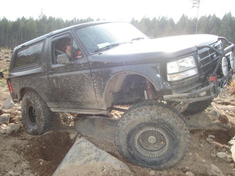 1989 Ford Bronco - Ford Bronco tackling a challenging off-road course with large rocks.