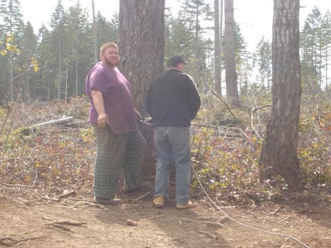 1989 Ford Bronco - Two men are standing in a forest clearing, surrounded by trees and underbrush.
