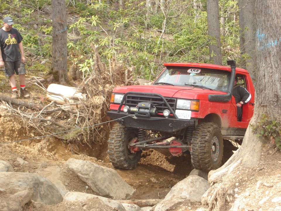 1989 Ford Bronco off-roading, red, with winch and snorkel