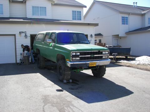 1990 Chevrolet Suburban - This lifted 1990 Chevrolet Suburban features a prominent grille and large off-road tires.