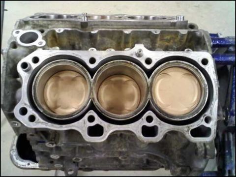 1994 Ford Probe - Close-up view of an engine block showing three pistons within their cylinders.
