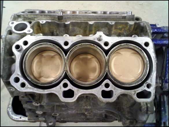 Engine block with three pistons visible