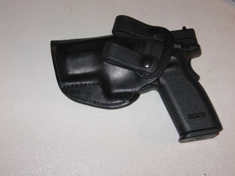2001 Ford F-150 - A black handgun is secured within a black leather holster, two snap closures for retention.