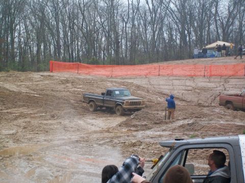1979 Ford F-250 - A 1979 Ford F-250 navigates a muddy off-road course with spectators in the background.
