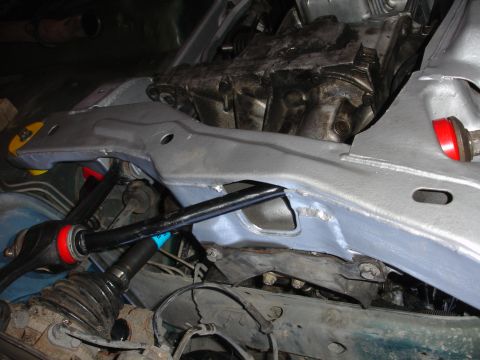 1995 Ford Taurus - Close-up view of a vehicle's subframe and suspension system, with parts of the engine visible.