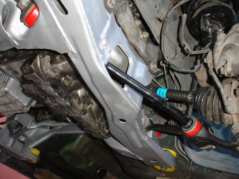 1995 Ford Taurus - Close-up view of a car's undercarriage, showing suspension components and drivetrain parts.