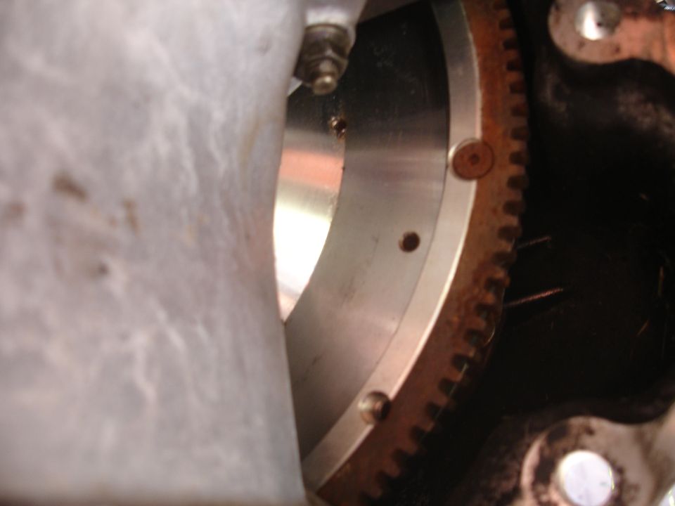 Close-up of a rusty starter ring gear attached to a metal flywheel