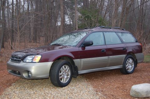 2001 Ford Crown Victoria - This Subaru Outback wagon is parked on a gravel driveway with a wooded area in the background.