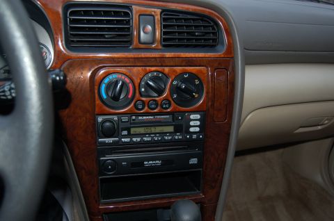 2001 Ford Crown Victoria - The dashboard features wood grain trim around the climate controls and the Subaru stereo system.
