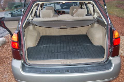 2001 Ford Crown Victoria - Rear view of a Subaru Outback's cargo area, showing the floor mat and folded rear seats.