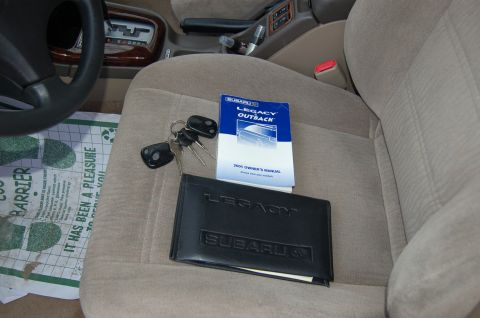 2001 Ford Crown Victoria - The owner's manual for a 2001 Subaru Legacy Outback is visible on the passenger seat next to a set of keys.