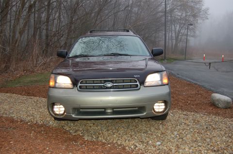 2001 Ford Crown Victoria - Subaru Outback Wagon front view, parked outdoors on a foggy day.