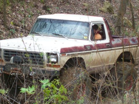 1978 Ford Bronco - This lifted Ford truck navigates a muddy, wooded trail with its front end angled towards the viewer.