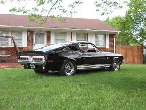 1968 Shelby GT500 - 1968 Shelby GT500 in black, seen from the rear 3/4 angle in a residential setting.