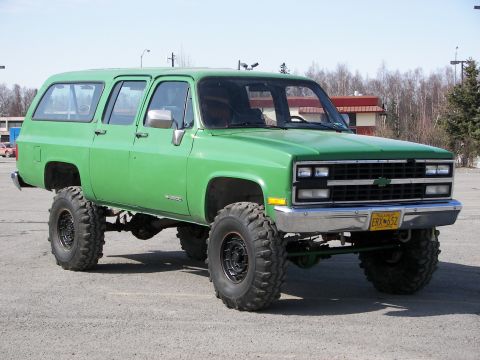 1990 Chevrolet Suburban - This lifted 1990 Chevrolet Suburban features oversized off-road tires and a vibrant green paint job.