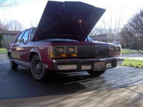 1990 Ford Crown Victoria LTD - Maroon 1990 Ford Crown Victoria LTD sedan parked with its hood open, showing the engine bay.
