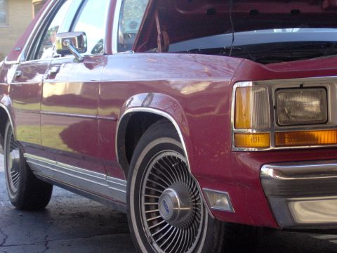 1990 Ford Crown Victoria LTD - Maroon 1990 Ford Crown Victoria LTD shown from the front quarter, hood up.