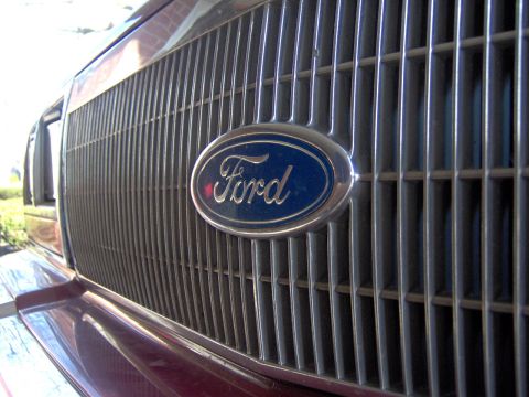 1990 Ford Crown Victoria LTD - The Ford emblem is centered on a vertical bar grille of a vehicle.