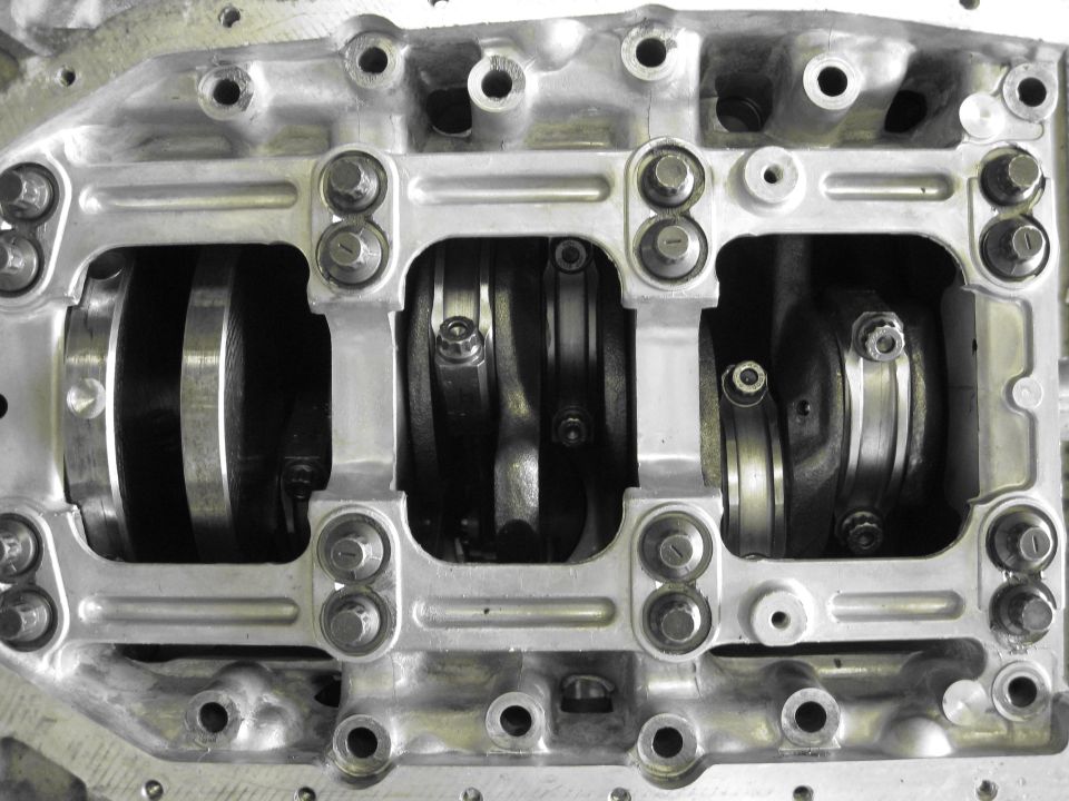 Engine crankshaft and connecting rods with bearing caps. Supermotors.net logo visible