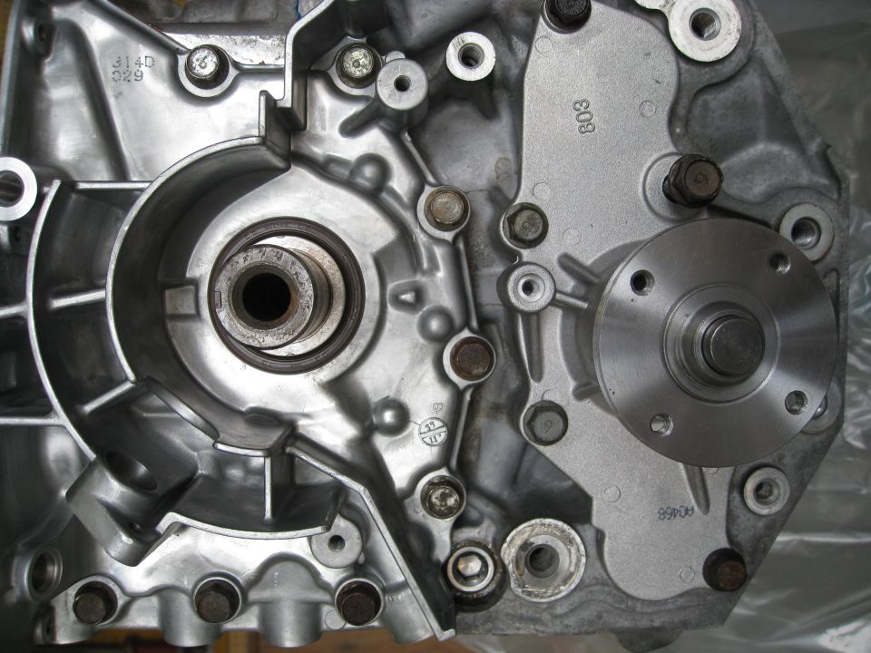 Close-up of a metal engine component with bolts and a circular flange