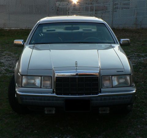 1990 Lincoln Mark VII - The front grille and headlights of a Lincoln Mark VII are visible in this outdoor shot.