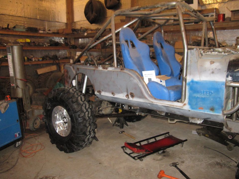 Custom off-road vehicle with roll cage and blue racing seats, side view