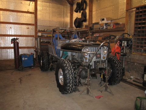 1992 Ford Bronco - This custom jeep is in a garage, possibly undergoing modifications or repairs.