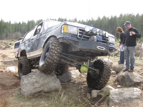 1979 Ford Bronco - This heavily modified SUV is navigating a challenging rocky terrain, its off-road capabilities.
