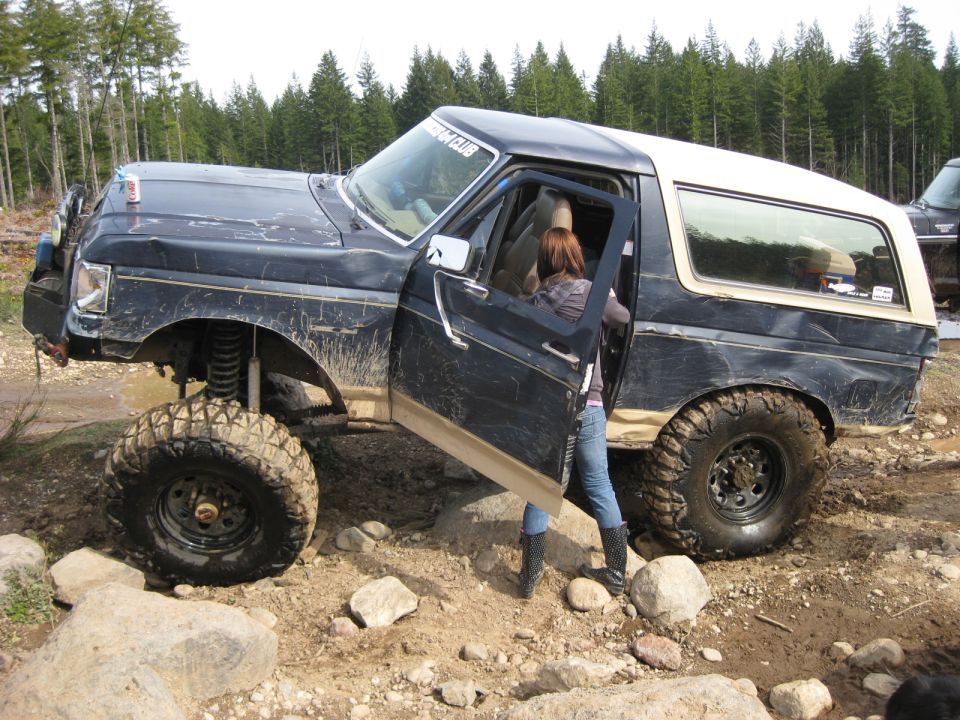 1979 Ford Bronco with lifted suspension and large tires, driver's door open