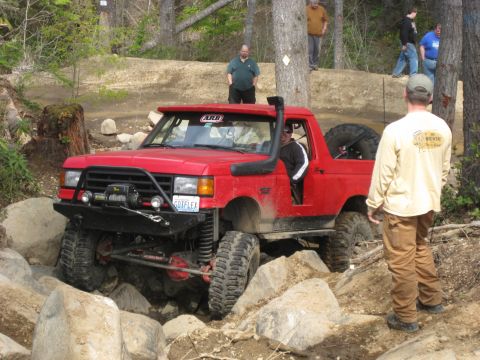 1979 Ford Bronco - A modified red off-road vehicle tackles a challenging rock crawling course.